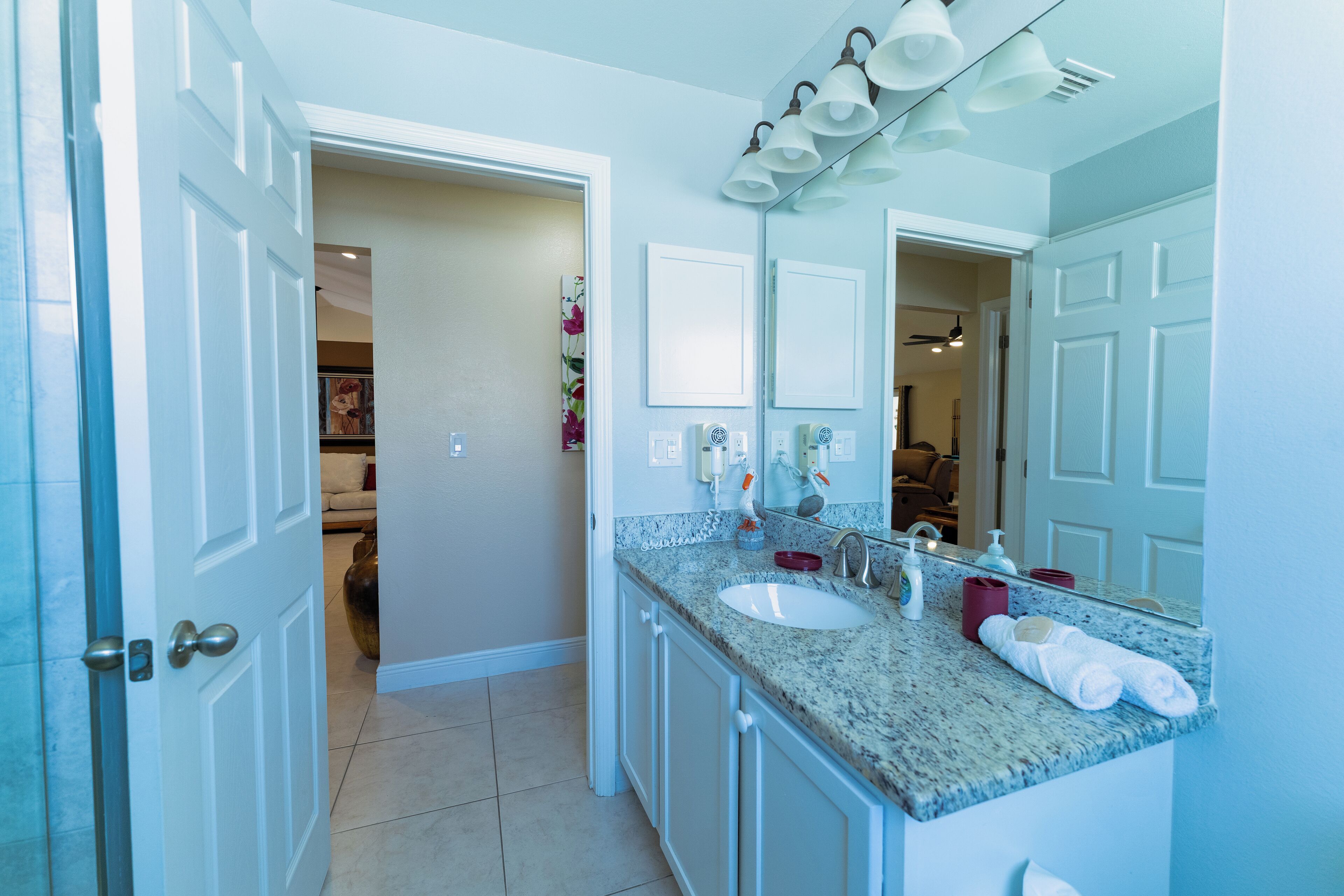 A bathroom with a sink, mirror, and towel rack.