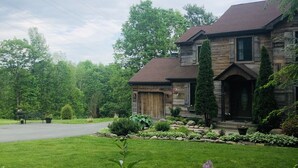 A two-story house with a stone facade and a large front yard. - Unique home in great neighborhood (Stroudsburg)
