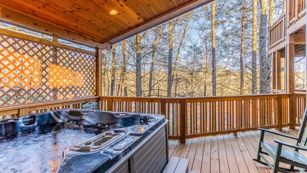 A wooden deck with a hot tub and a wooden fence. - Bearfoot Lodge at Echota Resort - Pool, Gym, Fishing Access, Private hot tub (Boone)