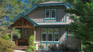 A two-story house with a porch, a wooden bench, and a stone wall. - Bearfoot Lodge at Echota Resort - Pool, Gym, Fishing Access, Private hot tub (Boone)