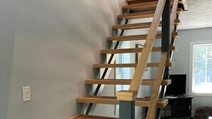 Una escalera de madera con barandilla azul en un interior moderno.