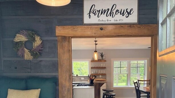 Un interior acogedor con un sofá azul verdoso, una zona de cocina y un comedor.