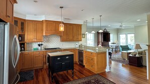 Una cocina amplia con armarios de madera, una isla central y un tapete grande.