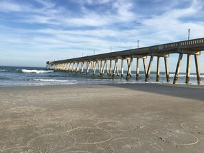 A pier extending into the ocean with a clear sky above.