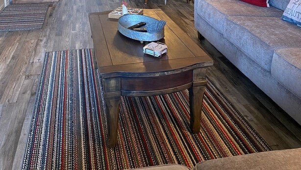 A living room with a sofa, coffee table, and dining area. There is a 'Welcome' sign on the wall and a 'Farmhouse' sign. - ••Newly remodeled and family friendly! AMAZING Strip views & close to it ALL!! (Branson)
