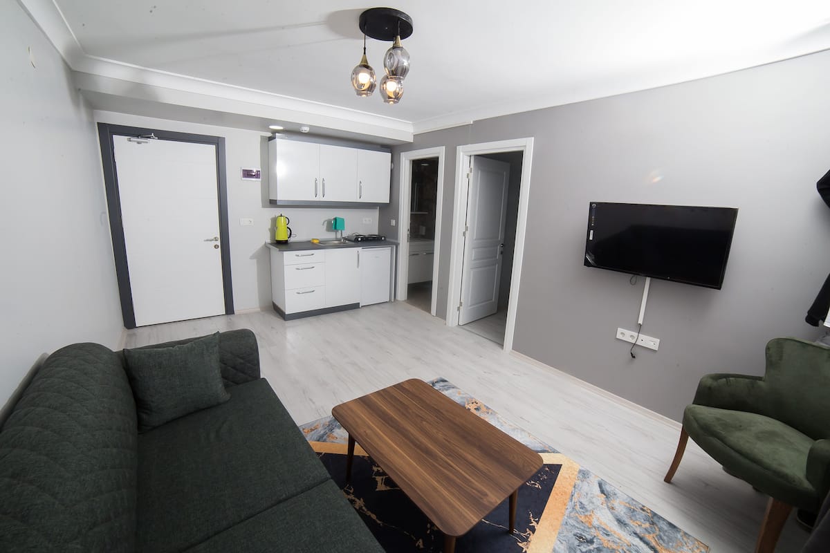 Suite familiar, 2 habitaciones | Área de sala de estar | Televisión LCD de 32 pulgadas con canales vía satélite y televisión
