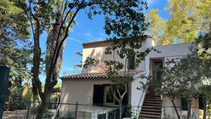 A two-story building with a tiled roof, a staircase, and a fenced garden area with trees and potted plants. - Farmhouse/ house hill (Parghelia)