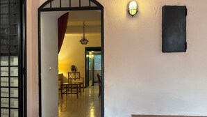 An interior view of a room with a tiled floor, a dining table with chairs, a hanging light fixture, and a door with a window. - Farmhouse/ house hill (Parghelia)