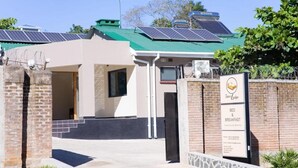 A building with a green roof, solar panels, and a sign advertising bed and breakfast services.