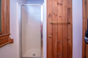 Una puerta de madera con manija de latón y una puerta de vidrio a la izquierda.