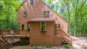 A wooden cabin with a deck, stairs, and a small porch area. - Trailside off West Side! (North Conway)