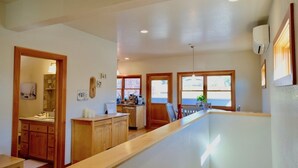A spacious kitchen with wooden cabinets, a countertop, and a view of the outside through large windows. -  Loft @ 420 on Chestnut (Mount Shasta)