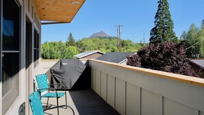 A balcony with a covered grill, a chair, and a view of a mountain. -  Loft @ 420 on Chestnut (Mount Shasta)