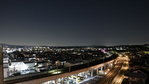A nighttime cityscape with a highway overpass, illuminated buildings, and a clear view of the urban landscape. - Hotel Wisteria Nara (Nara)