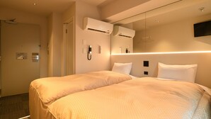 A hotel room with two beds, a large mirror, an air conditioning unit, a flat-screen TV, and a bedside table. - Hotel Wisteria Nara (Nara)