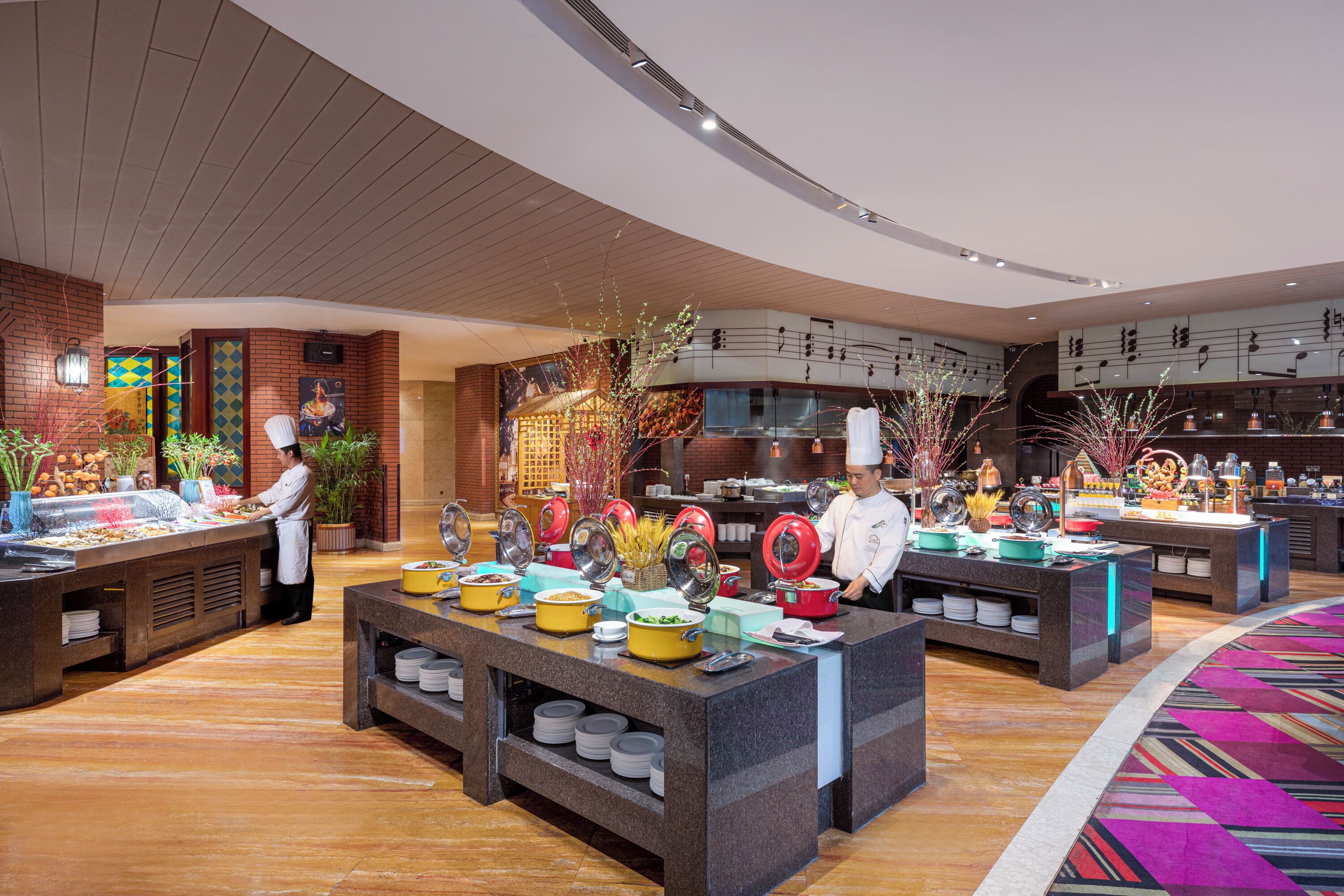 A buffet setup with multiple food stations, chefs, and a variety of dishes.