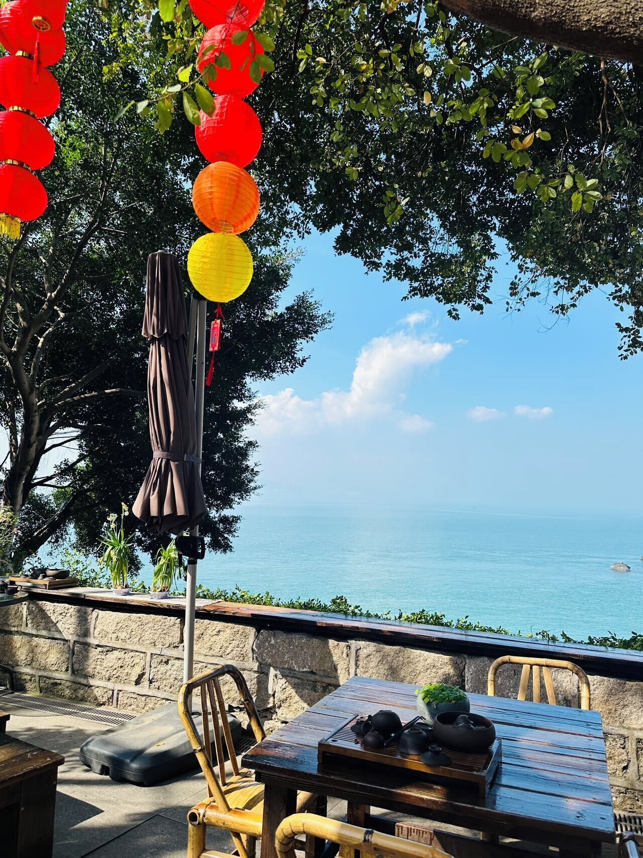 An outdoor seating area with a table, chairs, and a view of the sea.
