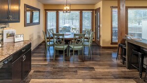 A kitchen with a dining table, chairs, and a bar area. - Family fun for all ages. Hot Tub, Bikes, Arcade, Private, Pets ok, SHARC, AC. (Sunriver)