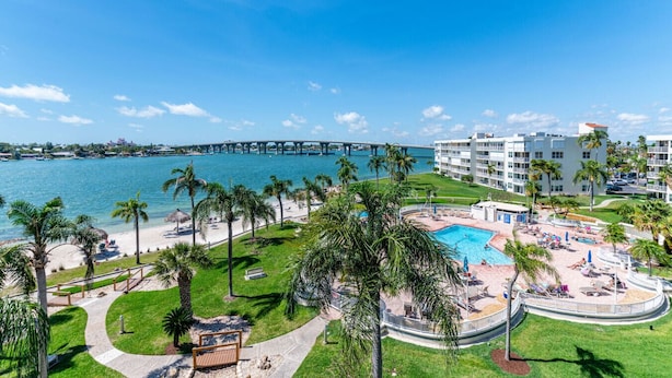 Ein Resort mit Pool, Palmen und Blick auf das Meer und eine Brücke.