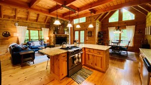 A spacious log cabin with a large kitchen, dining area, and living room.