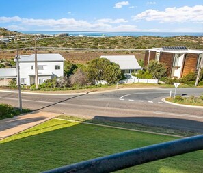 A residential area with houses, a road, and a sign indicating 'Pets Welcome Inside'.