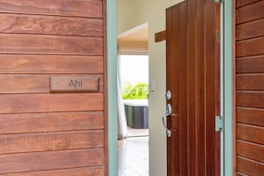 A wooden door with a nameplate reading 'Ahi' and a metal handle.