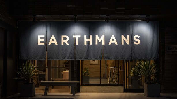 Exterior de un edificio con un gran letrero que dice 'EARTHMANS'.