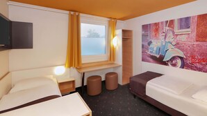 Een hotelkamer met twee bedden, een raam met gordijnen, een wandtelevisie, een klein tafeltje en een schilderij van een oldtimer.