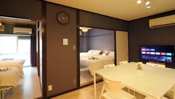A hotel room with a bed, a TV, a dining table, and a clock on the wall. - Shin-Osaka GRAND (Osaka)