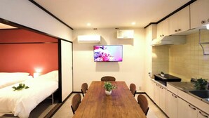 A compact room with a bed, a dining table, a TV, and a kitchenette. - Shin-Osaka GRAND (Osaka)