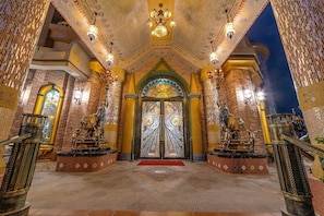 A grand entrance with a double door, ornate columns, and a patterned floor. - Hotel Moon (Xincheng)