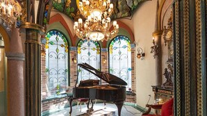 A grand hall with a grand piano, ornate columns, and a chandelier. - Hotel Moon (Xincheng)