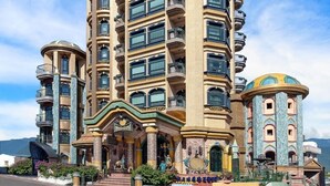 A multi-story hotel with a distinctive architectural design, featuring balconies and a central entrance with decorative elements. - Hotel Moon (Xincheng)