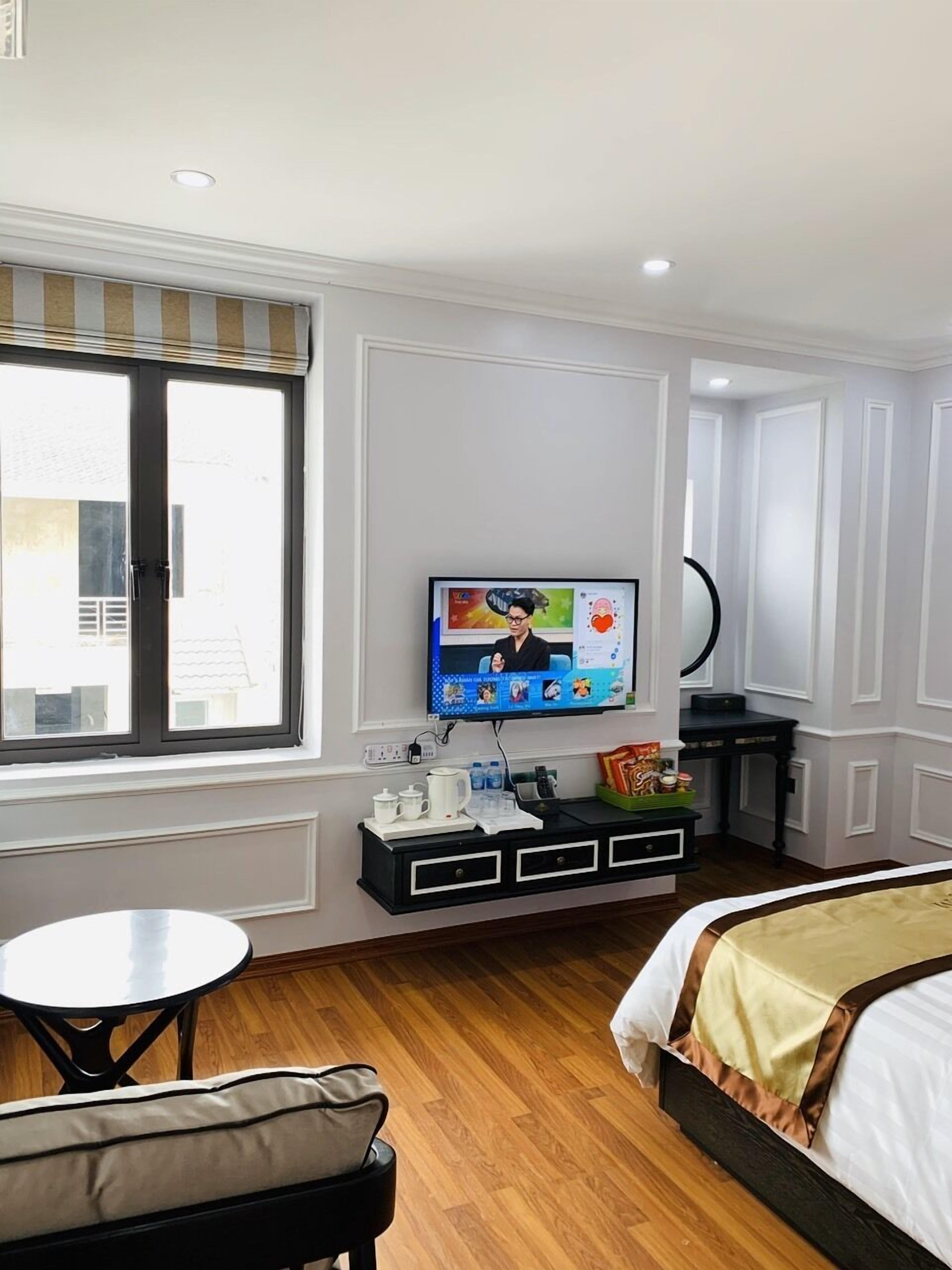 Une chambre d’hôtel avec un lit, une télévision, une petite table et une fenêtre.