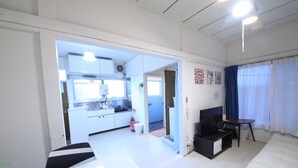 A compact room with a kitchenette, a bed, a desk, and a TV. - RESIDENTIAL HOTEL DAIICHI-H SHIN-OKUBO Room.A (Tokyo)