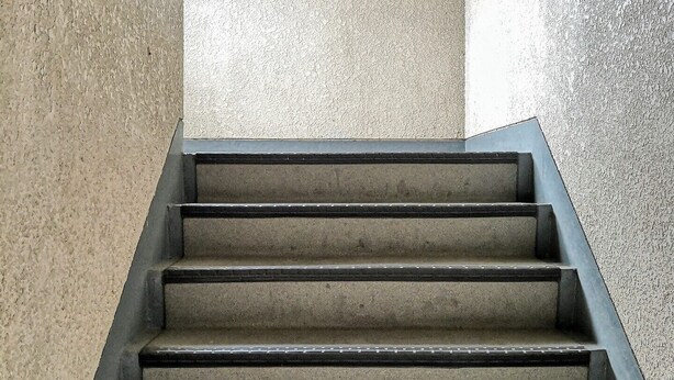 Betonstufen mit Metallgeländern, die zu einer höheren Etage führen.