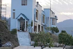 Un edificio de varios pisos con una escalera destacada que lleva a la entrada.
