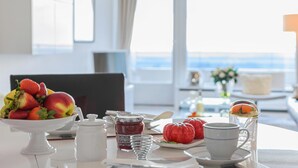 Ett frukostbord med frukt, en kopp, ett glas och en burk marmelad.