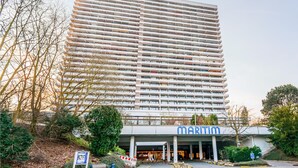Ett högt hotell med en modern design, som kännetecknas av en framträdande skylt med texten ”MARITIM” vid entrén.