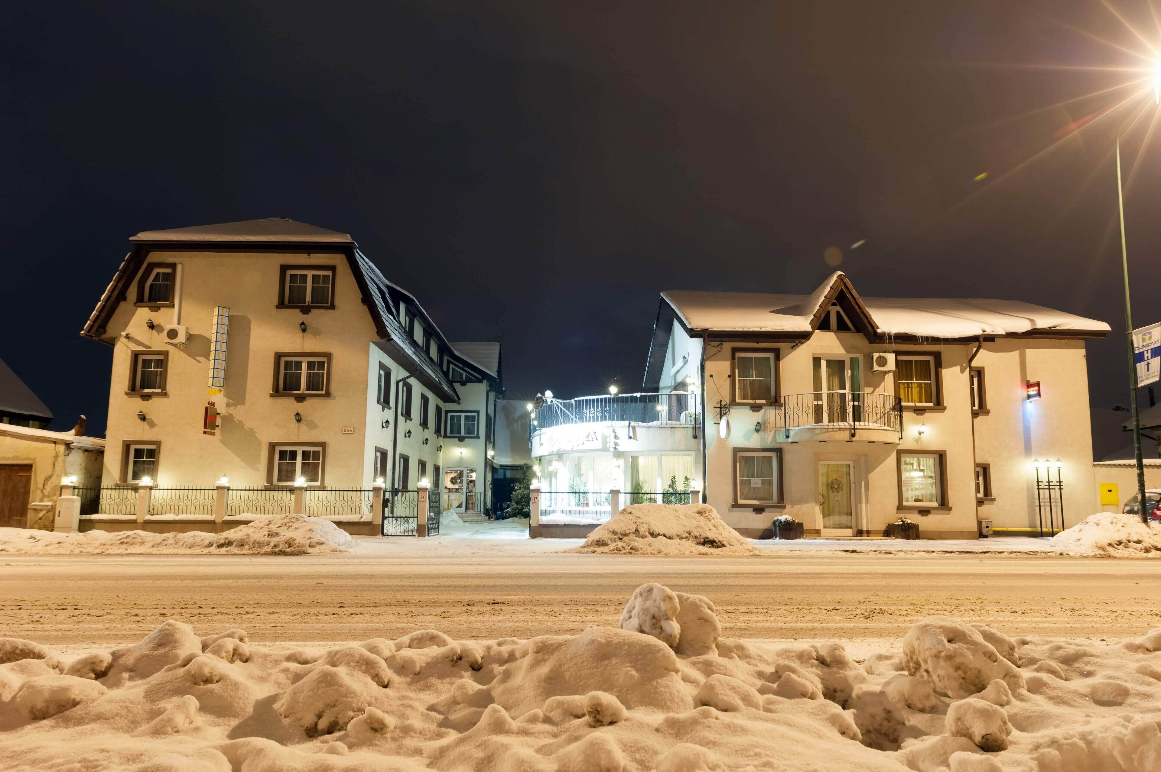 A hotel with multiple stories, balconies, and a snow-covered street.