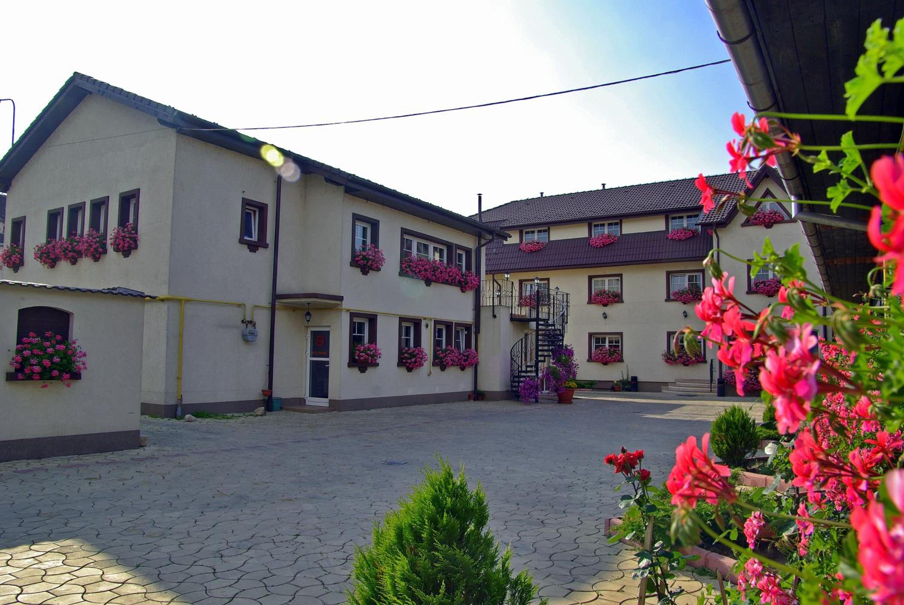 Un cortile con un edificio dotato di numerose finestre e fioriere.