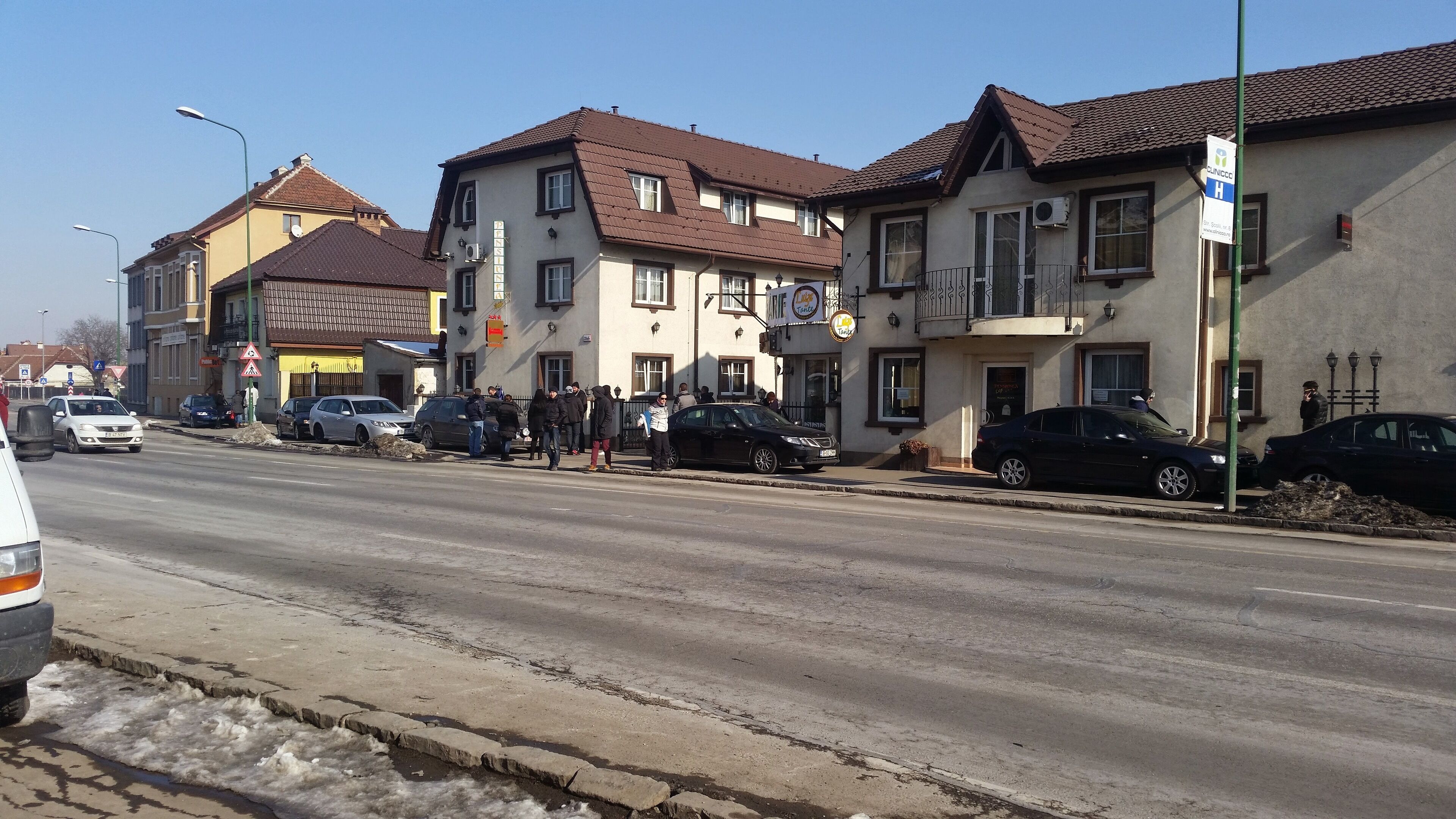 A street with buildings, cars, and pedestrians.