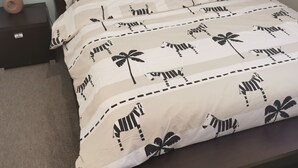 A bed with a zebra-patterned bedspread, two pillows, a nightstand with a lamp, and a dark headboard. - House Gite 6 persons near Illiers Combray LPE (Magny)