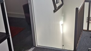 A room with a white door, a black railing, and a red rug on the floor. - House Gite 6 persons near Illiers Combray LPE (Magny)
