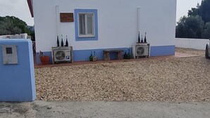 A white building with a blue window and two air conditioning units. - Cozy suite Marina house (Melides)