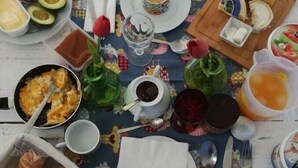 A breakfast spread on a table with various food items and drinks. - Cozy suite Marina house (Melides)