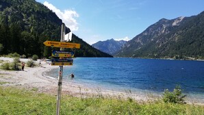 Un lac avec une chaîne de montagnes en arrière-plan et des panneaux indicateurs.