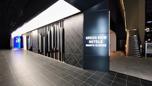Una entrada moderna de hotel con un letrero destacado para Green Rich Hotels Nagoya Nishiki.