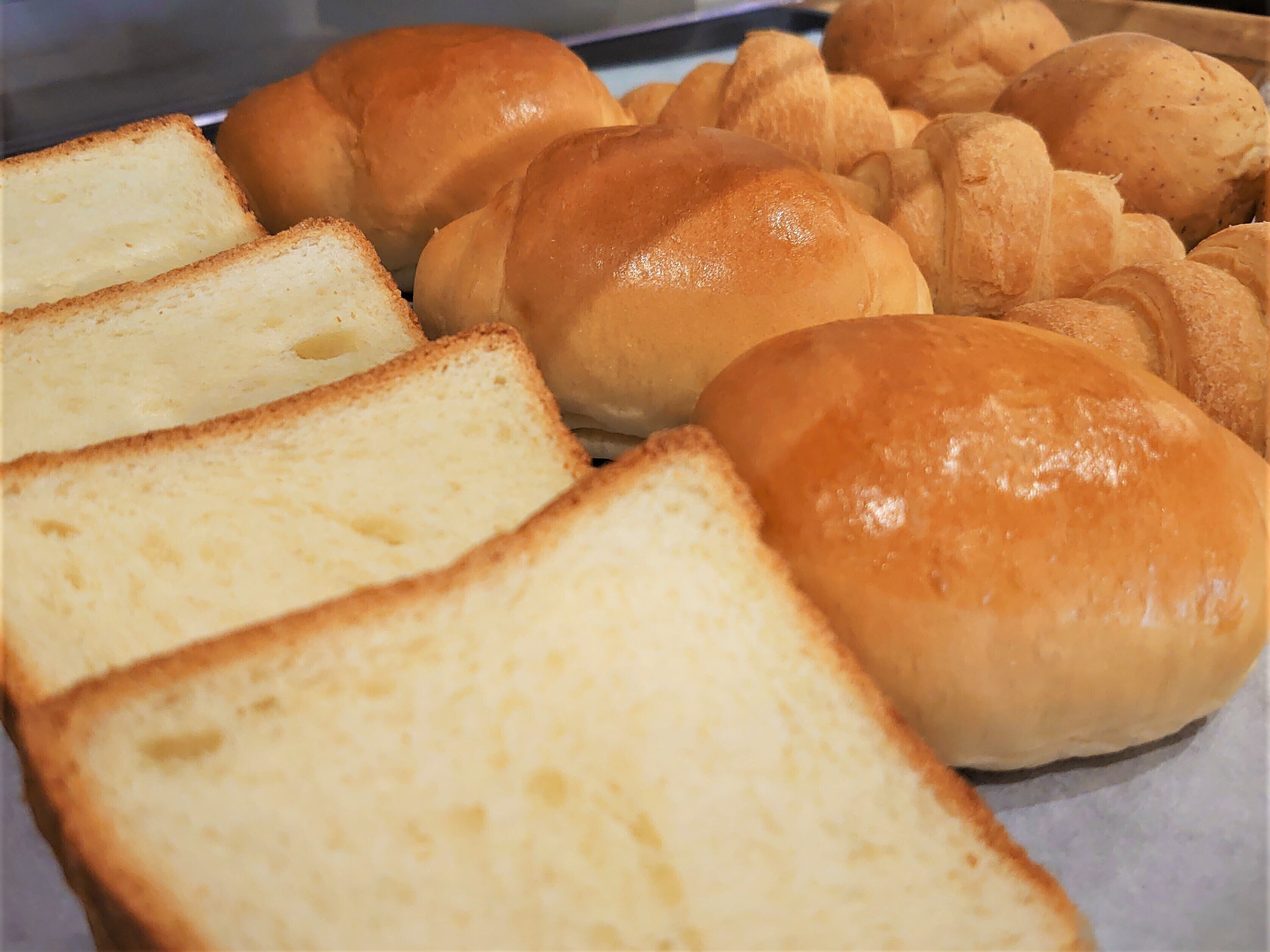 Una bandeja con varios tipos de panecillos y rebanadas.