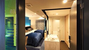 Una habitación de hotel con cama, mesita de noche y baño con lavamanos y espejo.